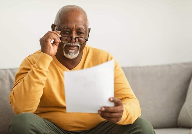 contented senior black man reading papers