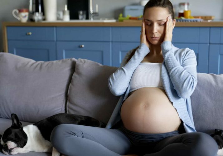 pregnant woman with headache at home Pregnant woman with headache at home