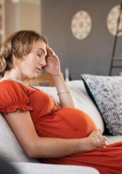 tired pregnant woman suffering headache