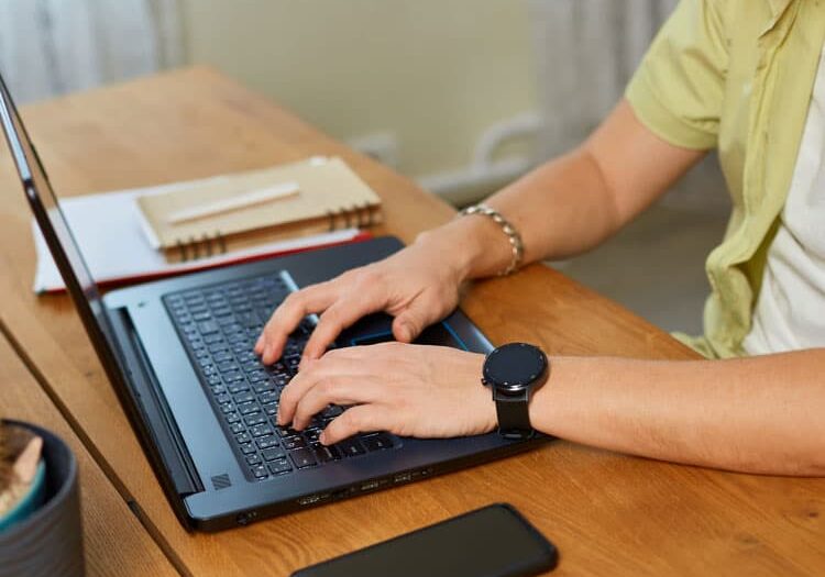 typing something on laptop working on computer